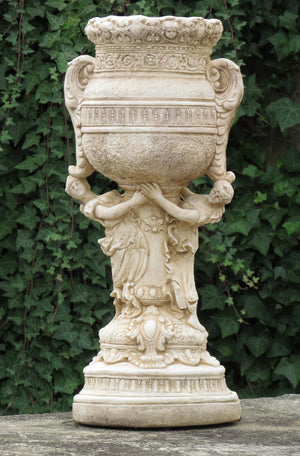 The Faraway Garden Antoinette Vase Planter is a beautifully proportioned planter with elaborate moulding including two characters holding up the bowl. This impressive planter works wonderfully on a lawn, in a rose garden or nestled in an herbaceous border. It makes a great focal point in a formal flower bed or raised on a plinth at the end of a green hedge walk.