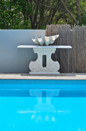 The Faraway Garden Console Table is an impressively proportioned side table that will make the perfect statement in an outdoor setting. Rectangular in shape with gently rounded top supported by an ornate leg with distinctive moulding.   This outdoor console table works perfectly situated beside the pool, an outdoor fire or on a terrace. It could also be used indoors or in a conservatory.