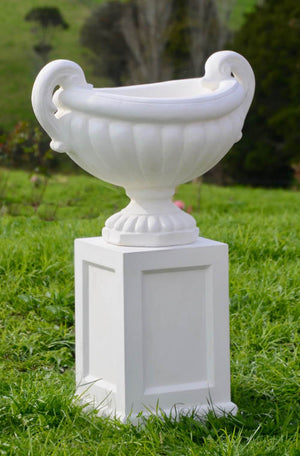 The Faraway Garden Amalfi Urn is an elegant garden planter inspired by the classical aesthetic of Ancient Greece with its distinctive swan shaped handles and linear moulding around bowl. Pictured here on our Tarrant Pedestal.  This unique garden planter would look gorgeous as part of a group or positioned on a Faraway Garden pedestal and the focal point at the end of pathway or the centrepiece of a rose garden.